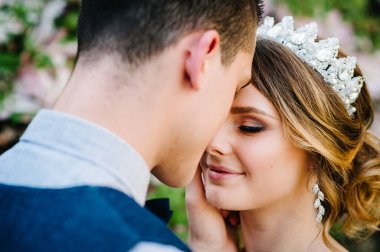 Şık, mutlu bir gelin, tacı ve damadı olan bir kadın, dostum. Yeni evliler sarılıyor. Kapatın. Doğanın arka planında. Düğünler, nişan, evlilik teklifi, randevu.