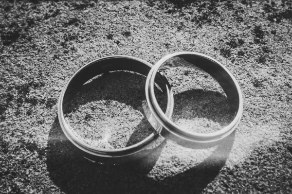 ラウンド大きな石の茶色の背景に結婚式の金の銀の婚約指輪 閉めろ 白黒写真 選択的焦点 — ストック写真