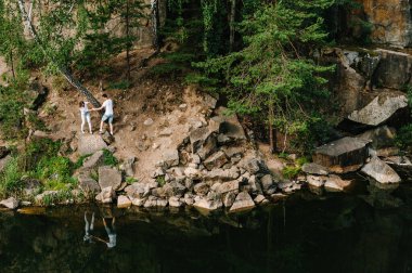 Bir adam ve bir kadın kayalar boyunca yürür, ağacın altında, ormanın ve gölün yanında emeklerler. Eski bir endüstriyel granit ocağının manzarası. Kanyon. Sonbaharın doğası. Metin ve tasarım için yer.
