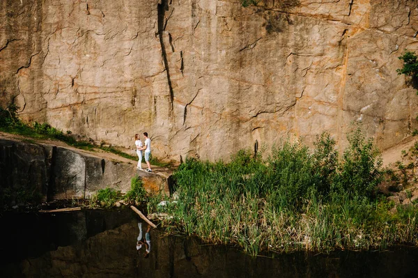 在岩石的背景下 人们站在湖畔拥抱的倒影 一个被水淹没的老工业花岗岩采石场景观 Canyon 秋天的本质 文本和设计的位置 — 图库照片
