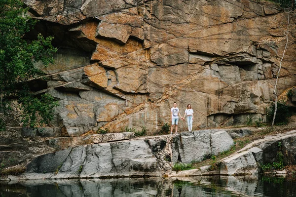男人和女人站在那里 看着岩石后面的摄像机 一个古老的工业花岗岩采石场的景观 Canyon 秋天的本质 文本和设计的位置 — 图库照片