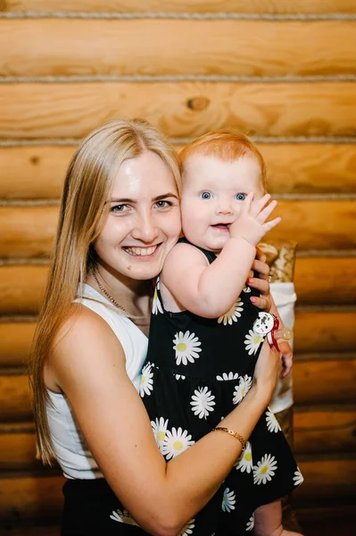 Ung Vacker Mor Med Liten Flicka Händerna Sitter Bakgrunden Trävägg — Stockfoto