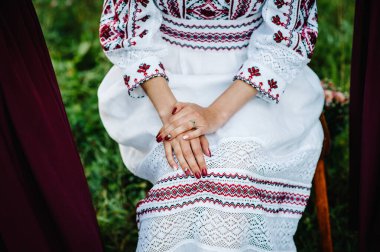 Kız elleri, manikür, yüzükler ve gelinlik, açık bahçede düğün hazırlıkları. Ukrayna tarzı: doğaya işlenmiş kıyafetler.