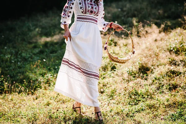公園内のバスケットウォークで花を持つボトムビューの女の子 屋外での結婚式で花嫁介添人の準備 ウクライナの素朴なスタイル 自然上の刺繍のドレスで花嫁 — ストック写真