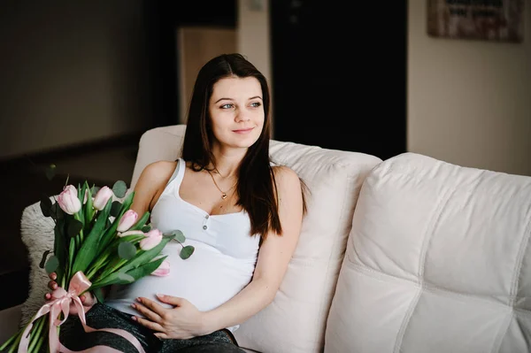 Mulher Feliz Grávida Sentada Cama Tocando Sua Barriga Segurando Buquê — Fotografia de Stock