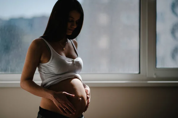 Esperando Bebé Mujer Embarazada Pie Cerca Ventana Las Manos Abraza — Foto de Stock