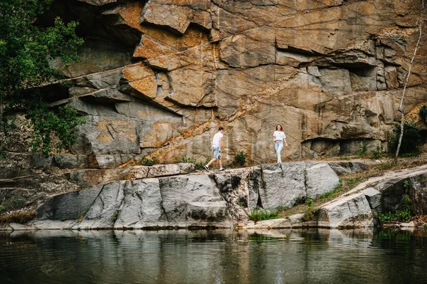 男人在岩石的背景下奔向女人 一个古老的工业花岗岩采石场的景观 Canyon 文字和设计的位置 — 图库照片