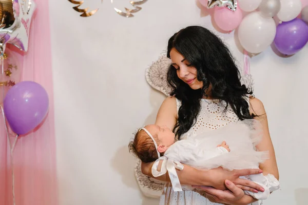 年轻母亲拥抱小孩女婴的肖像 用粉色 灰色背景和气球庆祝生日派对 幸福的家庭 — 图库照片