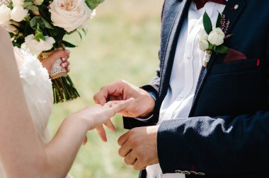 Damadın elleri gelinin parmağına nişan yüzüğü takar. Hazırlıklar. Düğün töreni. Mücevherler. Kapat..