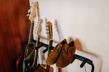 Müzik aletleri ve giysi arka plan konseptinin en üst görüntüsü. Deri ayakkabılar, akustik gitarların yanında. Vintage, instagram.