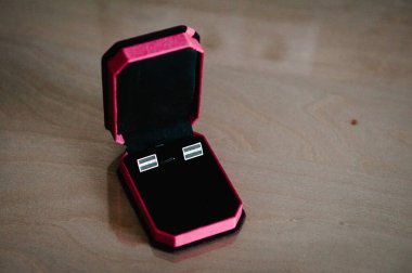 Damat kol düğmeleri masanın üstünde, zarif erkek kol düğmeleri. Aksesuarcı adamlar. Damadın düğün hazırlığı sabahı. Üst manzara, düz uzanma.