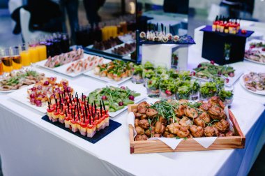 Masanın üzerinde farklı malzemelerle sunulmuş çeşitli mini aperatifler var. Bira için çeşitli İtalyan aperatifleri. Öğle yemeği kavramı. İş Yemeği Konsepti.