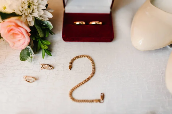 ウェディングアクセサリー花嫁 スタイリッシュな靴 イヤリング チェーン 白い背景に立ってテーブルの上に金のリング 平置きだ トップビュー — ストック写真