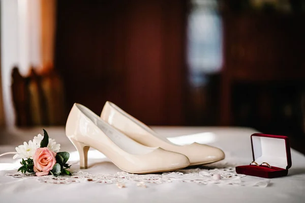 Düğün Aksesuarı Gelin Süslü Bej Ayakkabılar Altın Yüzükler Masada Çiçekler — Stok fotoğraf