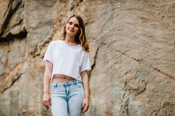 Slim Ragazza Alza Posa Scogliera Ritratto Donna Jeans Maglietta Bianca — Foto Stock