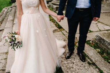 Gelin ve damat eski merdivenlerden iniyor. Eski şato, eski saray, düğün töreninden sonra. alt görünüm.