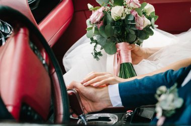 Gelin ve damat, yeni evli, balayı için kırsal bir yolda üstü açık eski arabalı düğün çifti. Gelin klasik bir arabada düğün buketi tutuyor. Mümkün. Yeni evlendi..