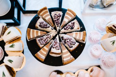 Güzel masa. Bir tabak kek ve kek. Şekerli masa, açık büfe. Parti şekerlemeleri için tatlı masası. Parti resepsiyonu, restoranda çok lezzetli süslenmiş. Çikolata. Üst görünüm.