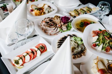 İnsanların kutlaması için çatal bıçak, yemek ve şarap dolu bir masa. Öğle yemeği kavramı. İş Yemeği Konsepti. Düz yat. en üstteki görünüm.