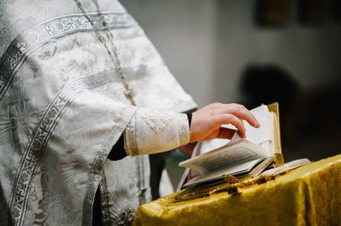 Rahip elinde İncil 'i tutuyor ve okuyor. Bir düğün töreninde rahip, kilisede bir ayini kutlar. Kapatın. Pazar okumaları, İncil..