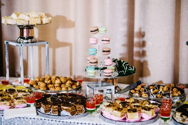 Sweet table. A plates of cakes and muffins. Table with sweets, buffet. Dessert table for a party goodies for the wedding. Candy bar. Decorated delicious.