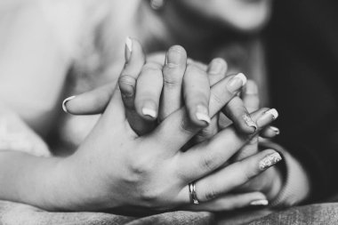 İki genç aşığın el ele tutuşması. Siyah beyaz fotoğraf.