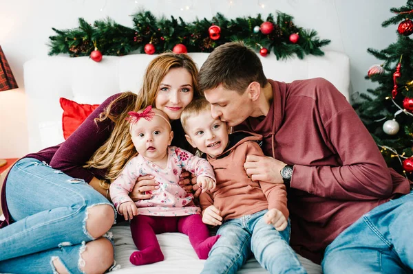 Vader Moeder Knuffelen Zoontje Dochtertje Bed Slaapkamer Bij Kerstboom Gelukkig — Stockfoto