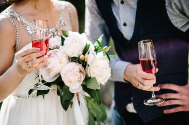 Bir buket şakayık ve damatla şık bir gelin. Bir bardak şampanya, içki. Evin avlusundaki arka planda. Düğün töreni. Kapat.