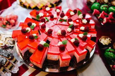 Güzel masa. Pastalı bir tabak. Şekerli masa, açık büfe. Parti şekerlemeleri için tatlı masası. Parti resepsiyonu, restoranda çok lezzetli süslenmiş. Şeker çubuğu.