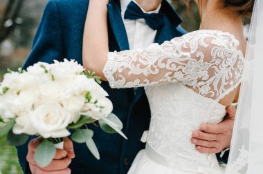 Gelin ve damat bir buketle doğadaki düğün töreninin üzerinde duruyorlar..