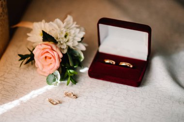 Düğün aksesuarı gelin. Beyaz arka planda duran altın küpeler..