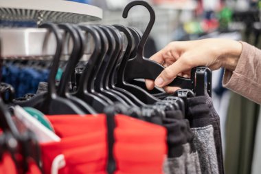 moda alışveriş merkezinde alışveriş yeni bir pantolon, seçtiğiniz bir kadın elinde yakın çekim