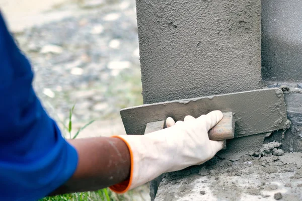 closeup of hand plastering cement on the wall in the construction work