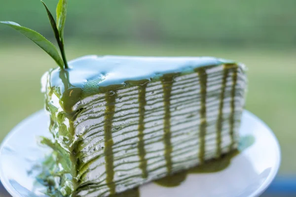 Primer Plano Pedazo Pastel Queso Verde Con Fondo Plantación Borroso —  Fotos de Stock