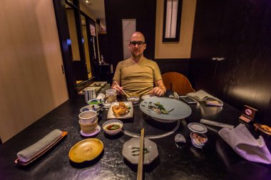 Tokyo - 20 Mayıs 2019: Ginza distri'de Pufferfish yiyen turistler