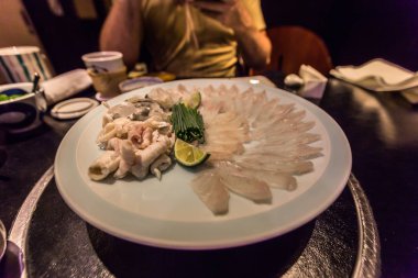 Tokyo - 20 Mayıs 2019: Ginza distri'de Pufferfish yiyen turistler