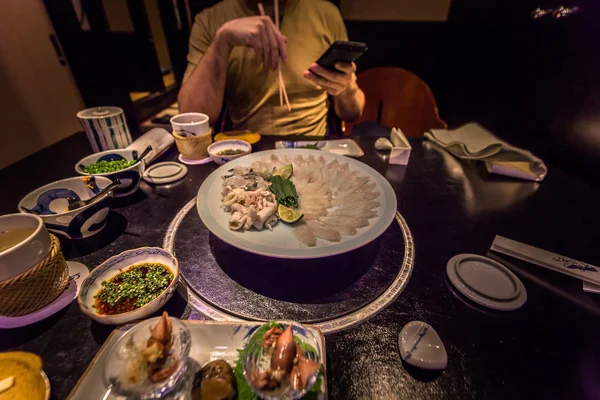 Tokyo - 20 Mayıs 2019: Ginza distri'de Pufferfish yiyen turistler
