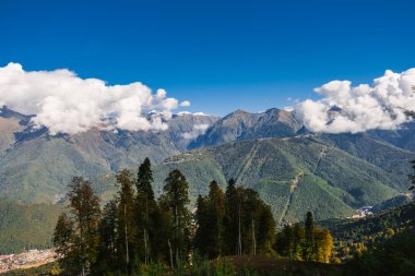Dağlarındaki sonbahar orman çalılar ve otlar ile kaplıdır. Renkli sonbahar manzara. Sıcak sonbahar güneşli bir gün. Bulutlar dağların üzerinden