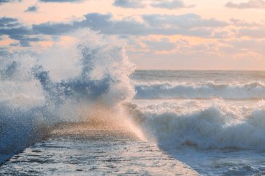Denizde fırtına. Dalgalar kıyıya kır. Deniz suyu güzel bir sprey. Bulutlar deniz üzerinde. Güneşli gün