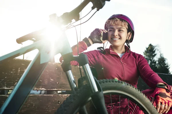 Young woman enjoying a day of cycling, resting and talking on her mobile phone