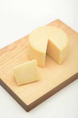 dilimlenmiş peynir kafa ahşap kesme tahtası ve beyaz yüzeye yakın çekim çekim