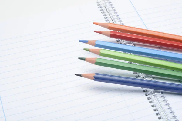 空白笔记本上彩色铅笔的特写镜头 — 图库照片