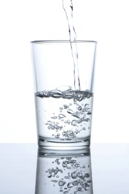 Beyaz arka planda bir bardağa su dökmek