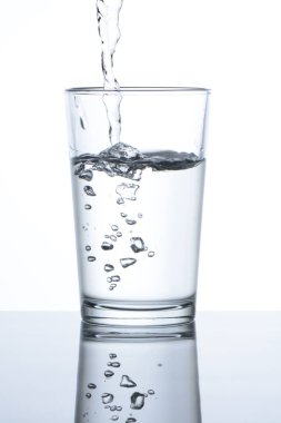 Beyaz arka planda bir bardağa su dökmek