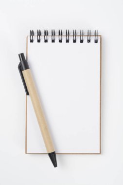 Beyaz arka planda boş bir defter ve bir kalem