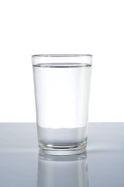 Beyaz zemin üzerinde su olan cam.