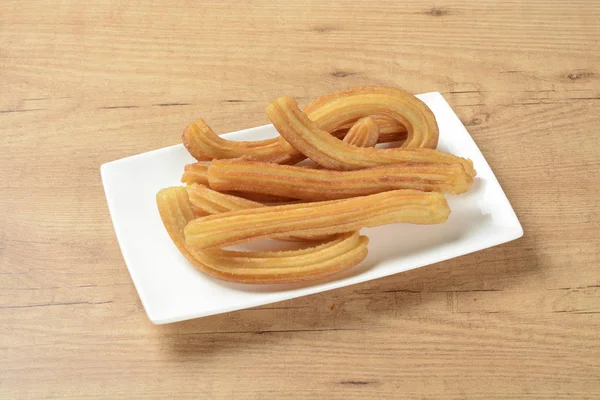 Kahverengi ahşap arka planda bir plaka üzerinde churros