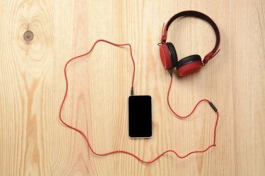 Ahşap zeminde telefon ve kulaklık