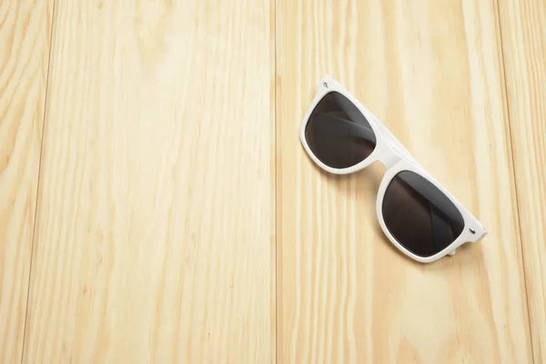 Fehér napszemüveg a fapadlón — Stock Fotó