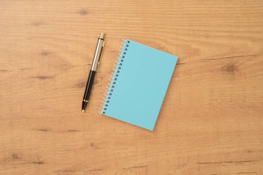 Defter ve kalem masaya. Yukarıdan görüntüle